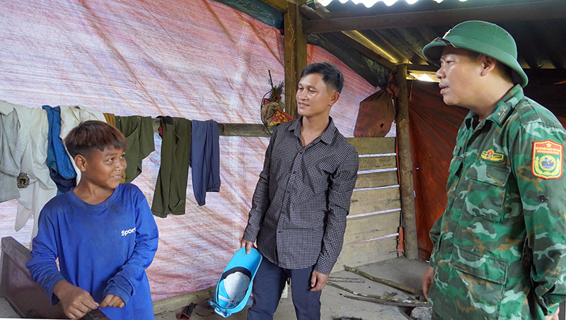 Thiếu tá Đinh Lâm Viên và trưởng bản Cao Xuân Long trò chuyện với cháu Lê.