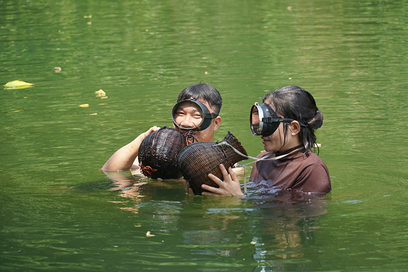 Hai chị em Thái Thị Hoa và Thái Thanh Hoàng lặn bắt ốc đực tại khe Rinh, Trung Hóa.