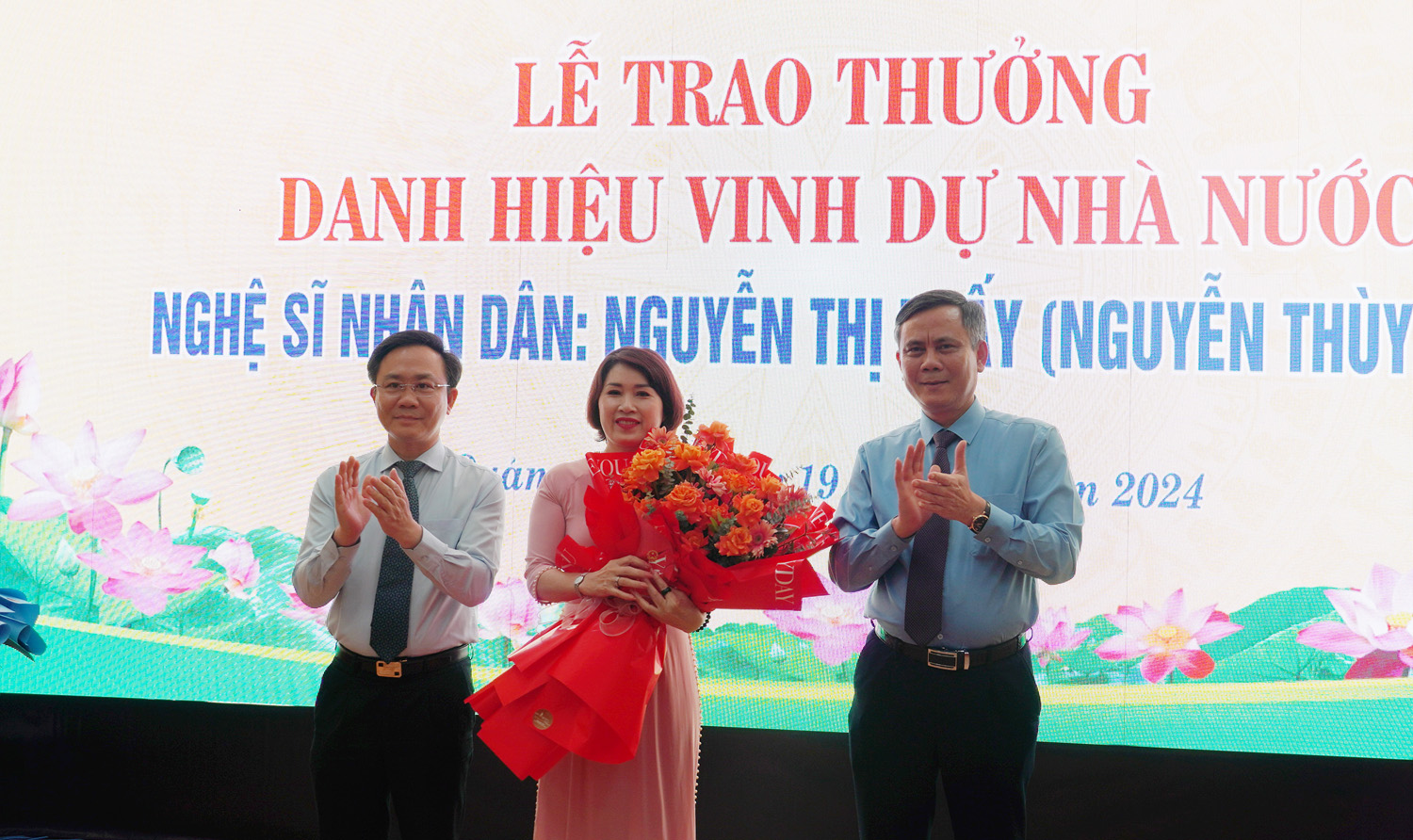 Đồng chí Chủ tịch UBND tỉnh Trần Thắng và đồng chí Phó Chủ tịch UBND tỉnh Hoàng Xuân Tân đã trao phần thưởng và hoa chúc mừng NSND Nguyễn Thị Thấy. 