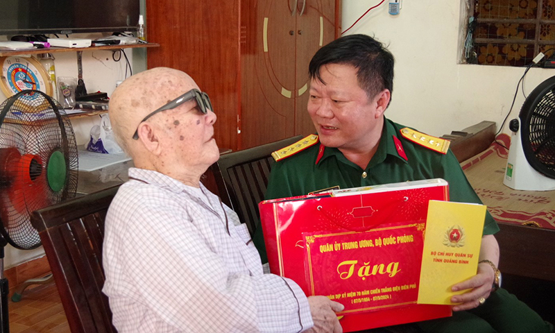 Đồng chí đại tá Trương Như Ý, Phó Chính ủy Bộ CHQS tỉnh tặng quà ông Đỗ Như Quán, ở xã Cảnh Dương (Quảng Trạch).