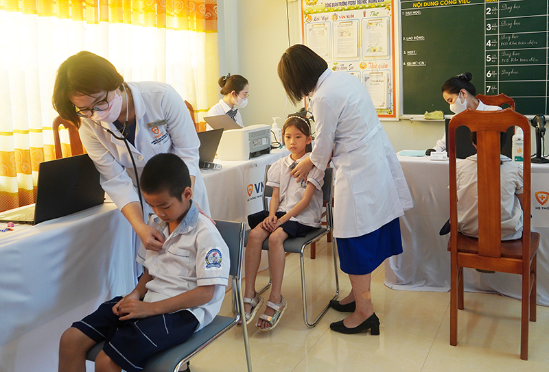 Các y, bác sỹ Bệnh viện Hoàn Mỹ Đà Nẵng đang khám cho các em nhỏ xã Trường Xuân.