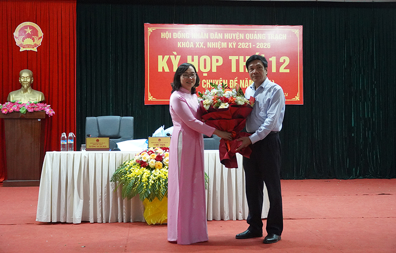 Đồng chí Phó Chủ tịch Thường trực HĐND tỉnh Nguyễn Công Huấn tặng hoa chúc mừng đồng chí Vũ Thị Mai.