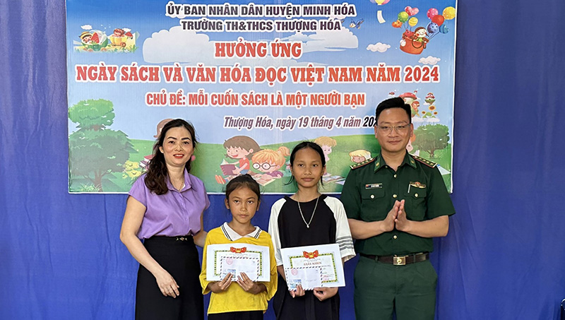 Đại úy Võ Huy Thắng tặng quà cho học sinh tại xã Thượng Hóa (Minh Hóa).