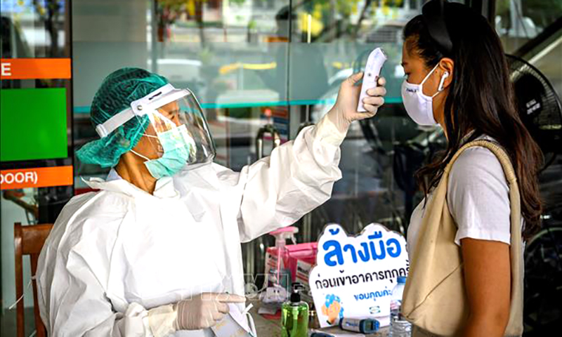 Nhân viên y tế kiểm tra thân nhiệt của người dân tại Bangkok, Thái Lan. Ảnh tư liệu: AFP/ TTXVN