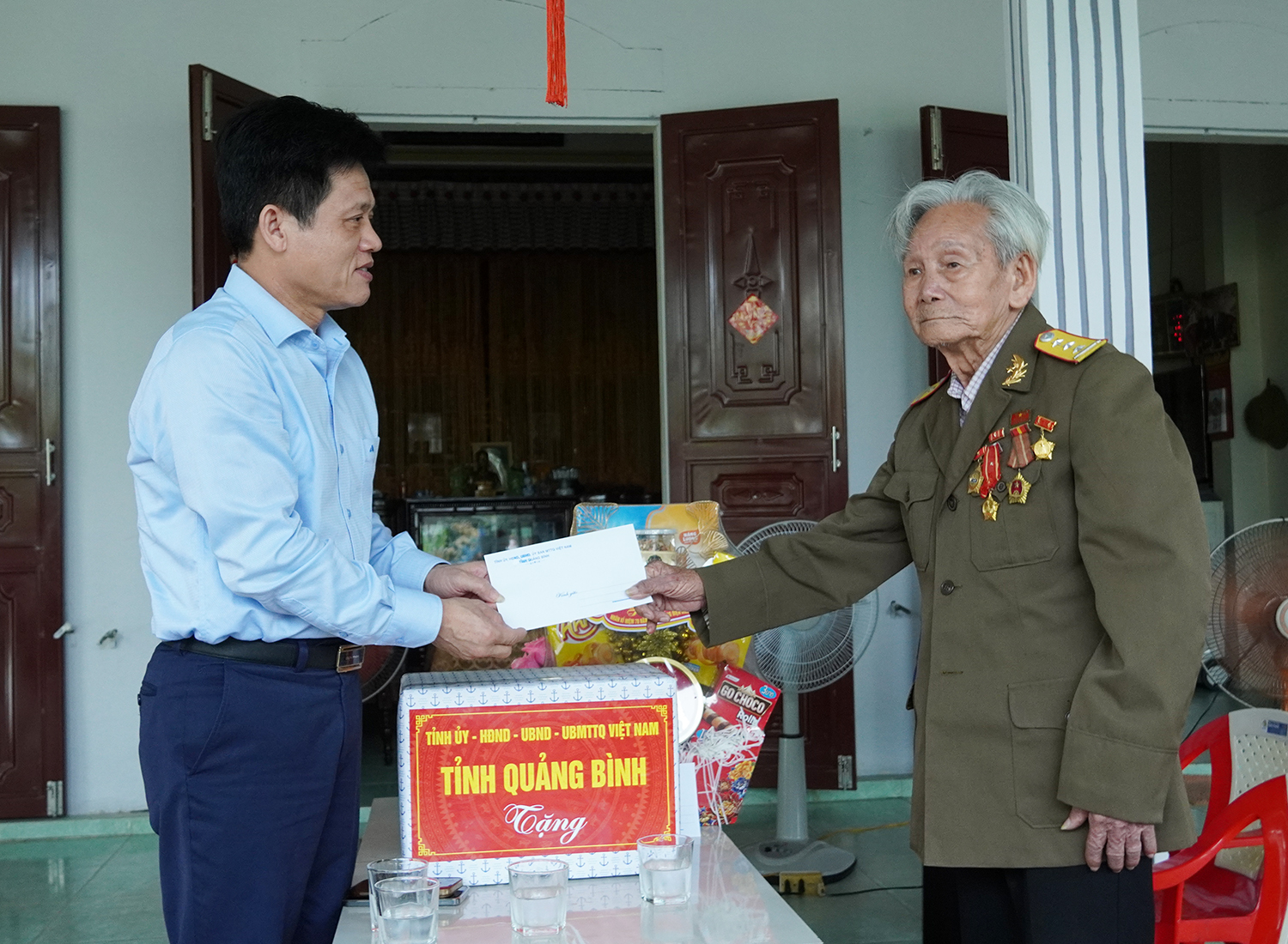 Đồng chí Chủ nhiệm Ủy ban Kiểm tra Tỉnh ủy Lê Văn Bảo tặng quà cựu chiến binh Nguyễn Văn Thu.