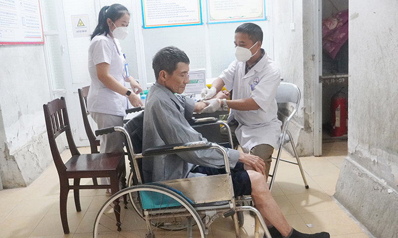 Các y bác sĩ Bệnh viện đa khoa huyện Tuyên Hóa khám bệnh cho người dân.