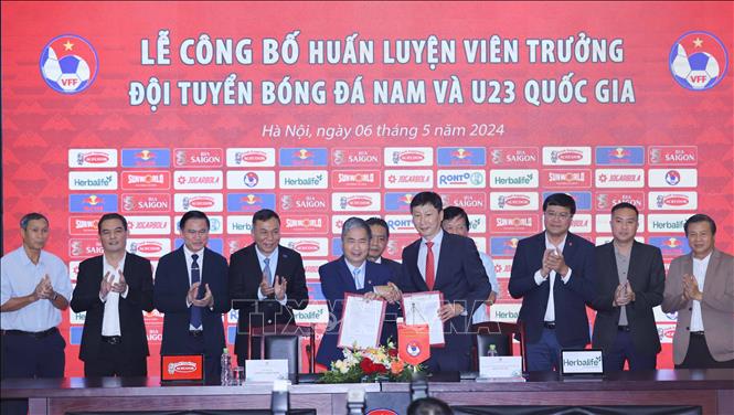 Lãnh đạo Liên đoàn Bóng đá Việt Nam (VFF) tặng hoa và áo cho HLV Kim Sang-sik. Ảnh: Thanh Tùng/TTXVN