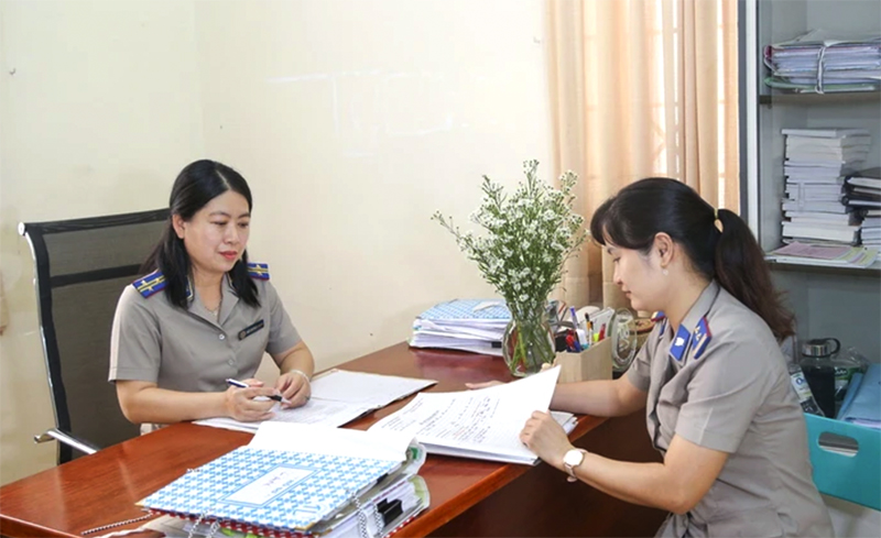 Bà Hồ Chí Bửu Nghi, Chi Cục trưởng, Chi Cục thi hành án dân sự Thị xã Hòa Thành, tỉnh Tây Ninh (bên trái) trao đổi xử lý vụ việc thi hành án khó cùng chấp hành viên. (Ảnh: Giang Phương/TTXVN) 