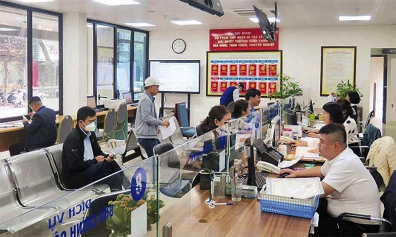 Người dân đến làm thủ tục tại bộ phận “một cửa” Ủy ban nhân dân quận Đống Đa. (Ảnh: QUỐC TOẢN)