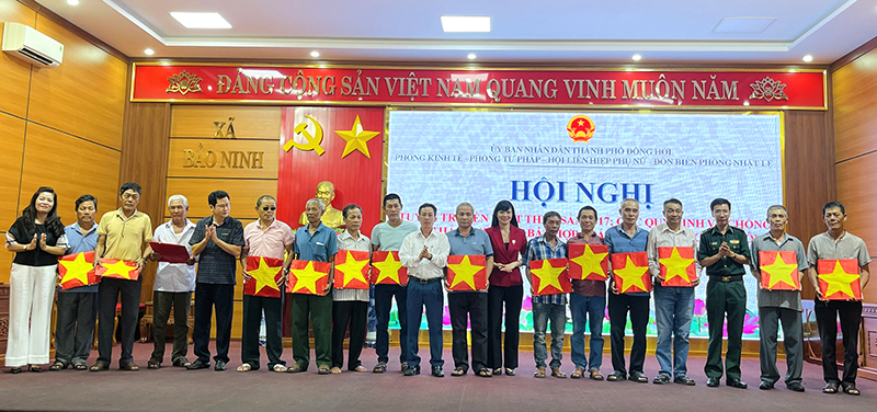 Đại diện lãnh đạo Hội LHPN TP. Đồng Hới và Ban Tổ chức tặng cờ Tổ quốc cho ngư dân.