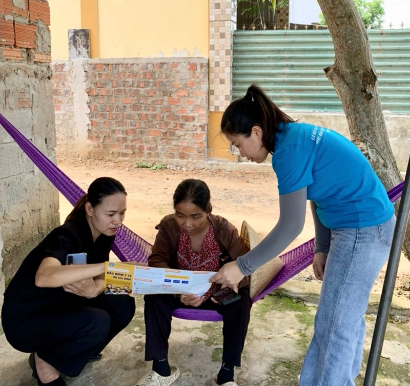 Nhân viên thu BHXH tích cực tuyên truyền chính sách BHYT hộ gia đình cho người dân.