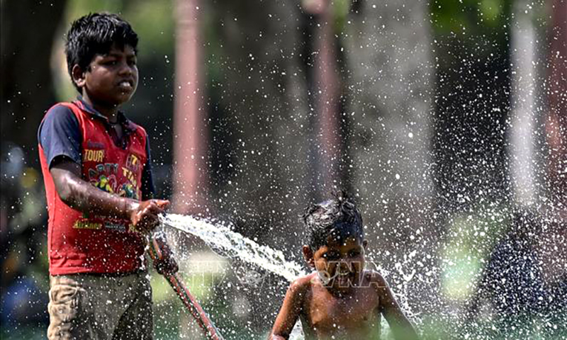  Trẻ em chơi đùa với nước trong ngày nắng nóng tại New Delhi, Ấn Độ, ngày 31/5/2024. Ảnh: AFP/TTXVN