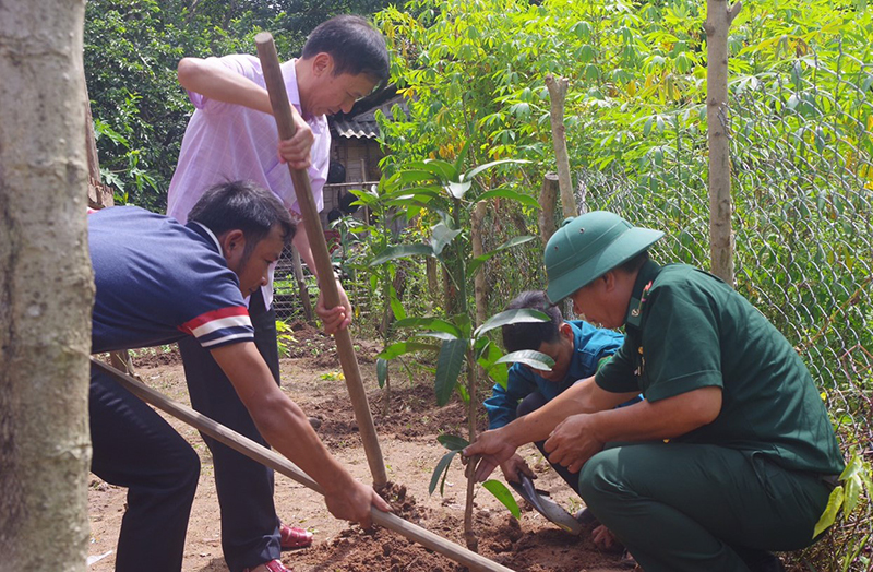 Cán bộ làm công tác dân vận huyện Bố Trạch cầm tay chỉ việc, hướng dẫn bà con cách trồng trọt.