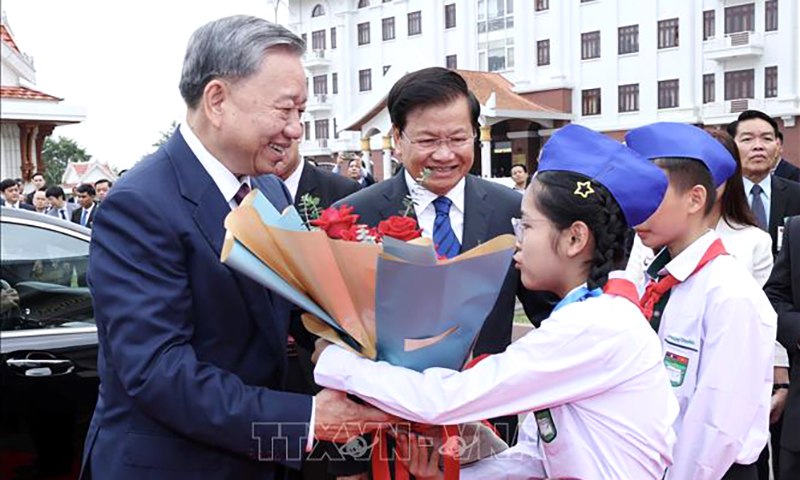 Thiếu nhi Thủ đô Vientiane tặng hoa, chào mừng Chủ tịch nước Tô Lâm thăm cấp Nhà nước tới CHDCND Lào. Ảnh: Nhan Sáng/TTXVN