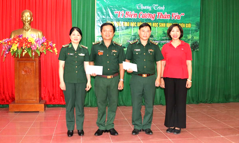 Cô Trần Thị Bích Liên, Hiệu trưởng Trường Tiểu học chất lượng cao Tràng An (bên phải) và Thượng tá QNCN Hồ Thị Bảo Ngọc, đại diện Báo Biên phòng (bên trái) trao quà tặng Đồn BP Cồn Roàng và Chương trình “Nâng bước em tới trường - Con nuôi đồn Biên phòng” của Đồn Biên phòng Cồn Roàng. Ảnh: Bích Nguyên