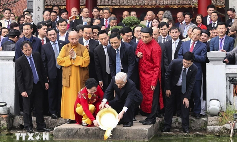  Tổng Bí thư, Chủ tịch nước Nguyễn Phú Trọng và Phu nhân cùng kiều bào tham dự Chương trình Xuân Quê hương năm 2019 thực hiện nghi thức thả cá chép theo phong tục truyền thống tại hồ Hoàn Kiếm, Hà Nội. (Ảnh: Trí Dũng/TTXVN).