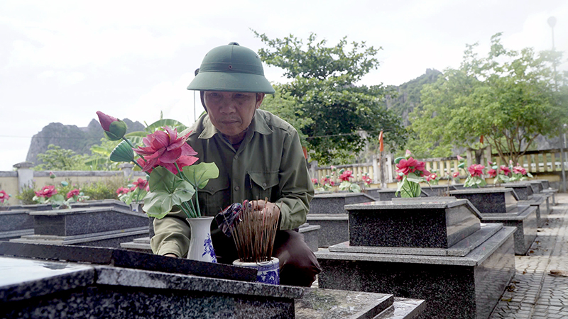 Cựu chiến binh Nguyễn Văn Quyền cần mẫn lau dọn nghĩa trang liệt sỹ.