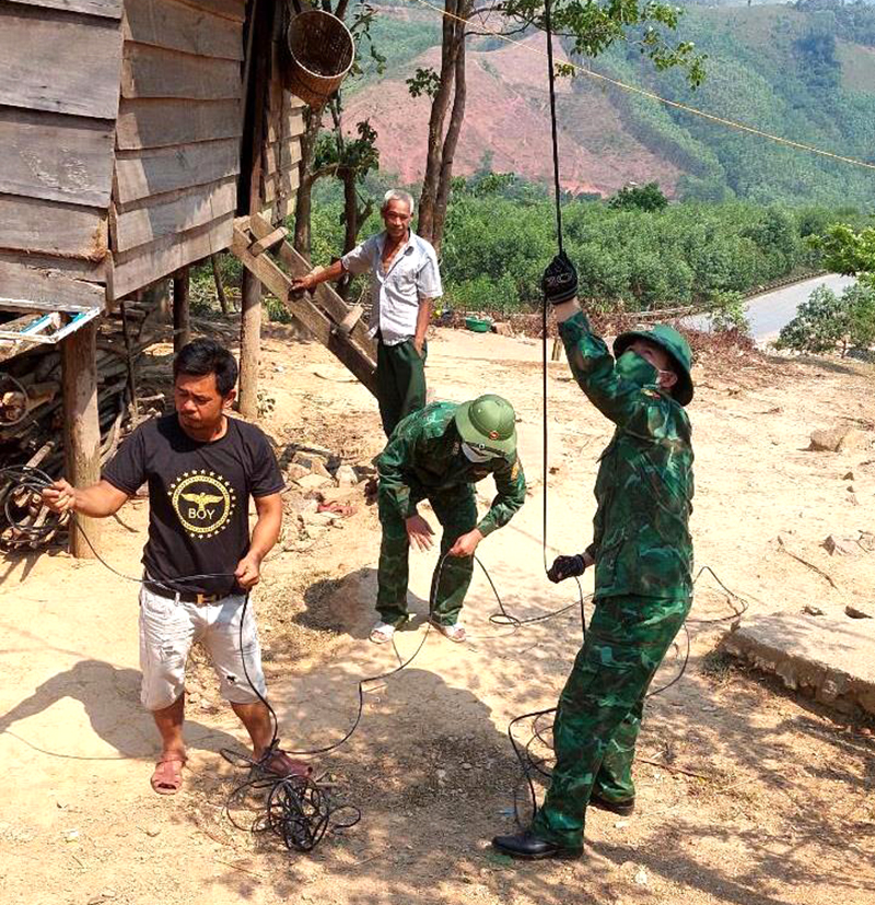 Cán bộ, chiến sĩ Đồn Biên phòng CKQT Cha Lo cùng người dân bản Ka Ai kéo đường dây để triển khai mô hình “Truyền thanh bản xa”. Ảnh: Nguyễn Thành Phú