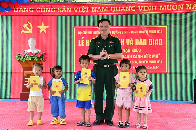 Đại diện lãnh đạo Bộ CHQS tỉnh tặng quà cho các cháu học sinh.