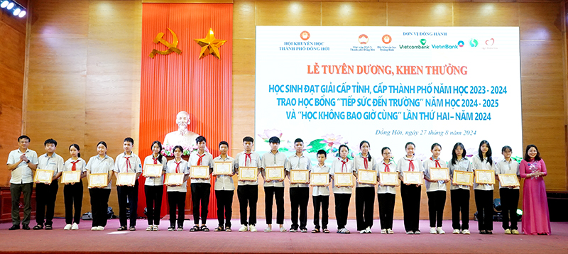 Đại diện lãnh đạo TP. Đồng Hới trao thưởng cho các học sinh đạt giải học sinh giỏi cấp thành phố.