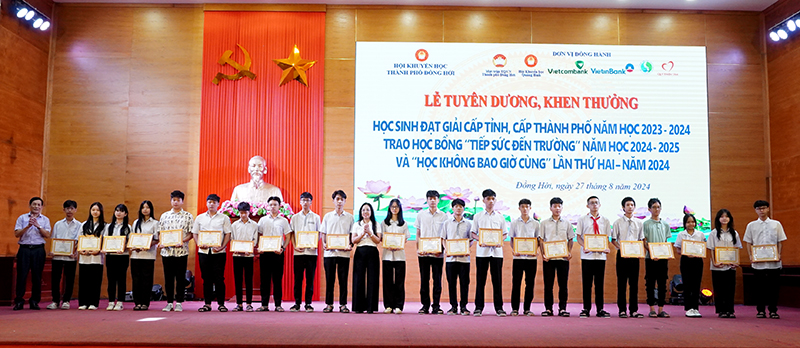 Đại diện lãnh đạo TP. Đồng Hới trao thưởng cho các học sinh đạt giải học sinh giỏi cấp thành phố.