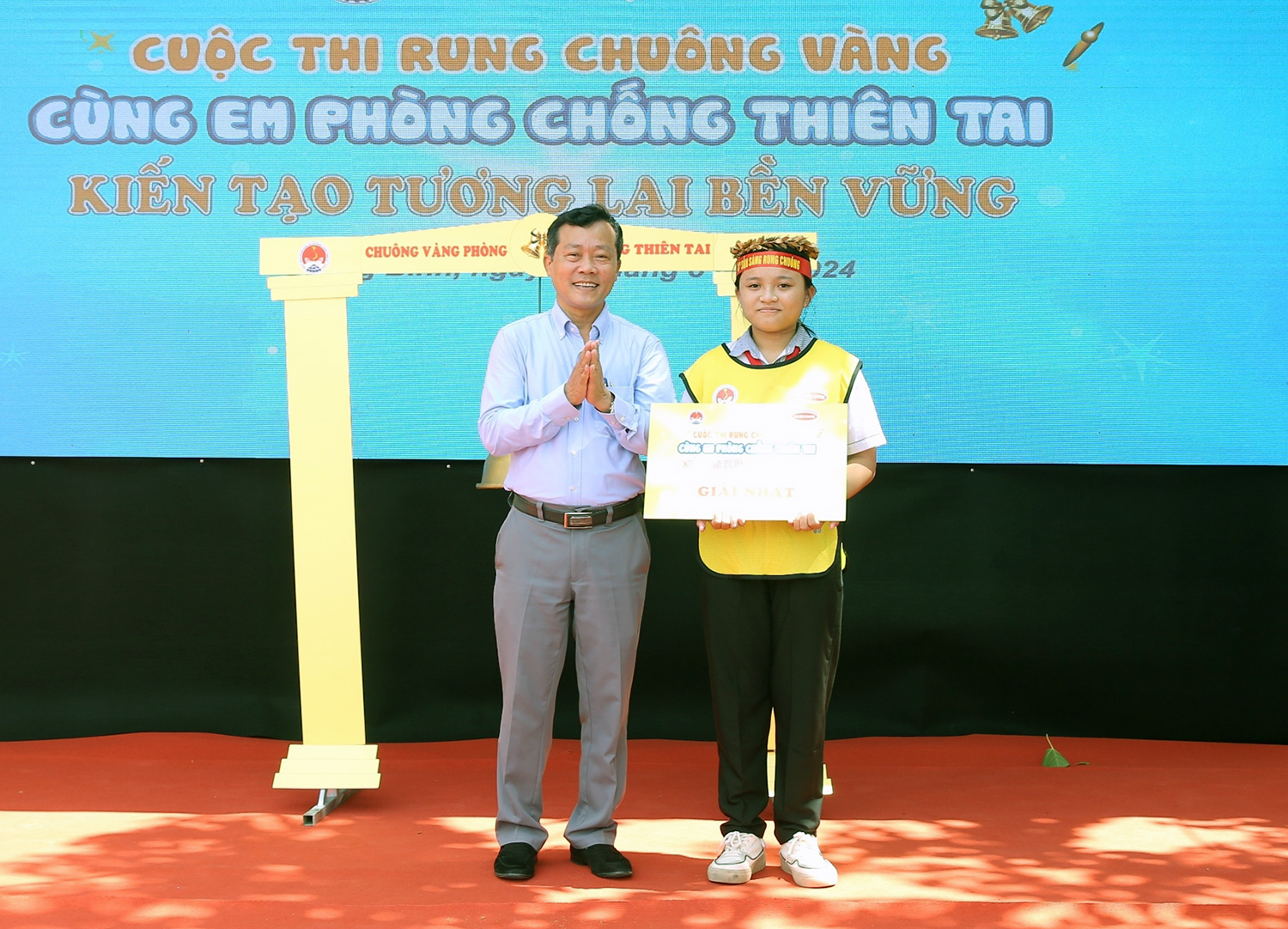 Đồng chí Nguyễn Văn Tiến, Phó Cục trưởng Cục Quản lý đê điều và phòng chống thiên tai trao giải nhất cho em Dương Phương Thảo, Trường THCS Tân Ninh.