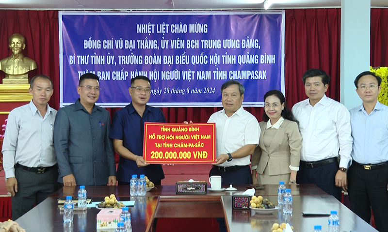 Đồng chí Bí thư Tỉnh ủy Vũ Đại Thắng trao biển tượng trưng hỗ trợ Hội Người Việt Nam tại tỉnh Chăm-pa-sắc số tiền 200 triệu đồng.