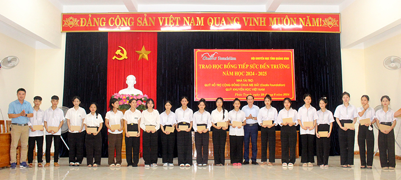Đại diện lãnh đạo Phòng Giáo dục-Đào tạo huyện, nhà tài trợ và cô giáo trao học bổng cho các học sinh.