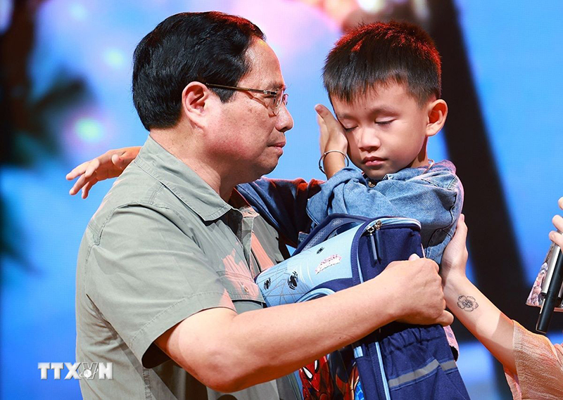 Đồng chí Thủ tướng Phạm Minh Chính động viên cháu Nguyễn Quốc Bảo (sinh năm 2016) bị mất cả bố và chị gái khi 3 người bị nước lũ cuốn trôi trong lúc di chuyển bằng xe máy qua cầu tràn thôn Cầu Treo, xã Yên Thuận, huyện Hàm Yên, tỉnh Tuyên Quang. (Ảnh: Dương Giang/TTXVN)