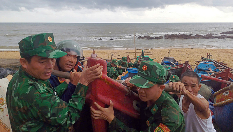 Cán bộ, chiến sĩ Đồn Biên phòng Lý Hòa giúp nhân đưa tàu thuyền đến nơi an toàn