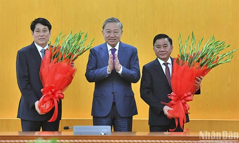 Đồng chí Tổng Bí thư Tô Lâm tặng hoa chúc mừng đồng chí Lương Cường và đồng chí Trần Cẩm Tú. (Ảnh: ĐĂNG KHOA)