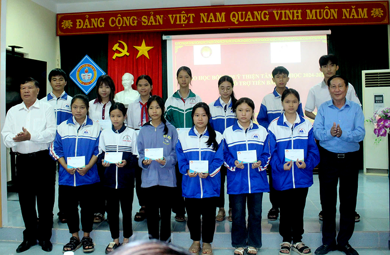 Đại diện lãnh đạo Hội Khuyến học tỉnh và lãnh đạo huyện Lệ Thủy trao học bổng cho học sinh vượt khó học giỏi. 