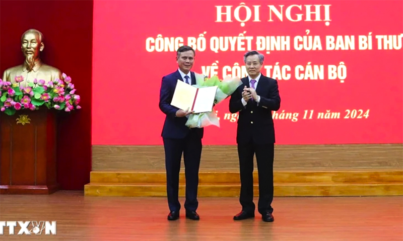 Ông Nguyễn Quang Dương trao quyết định, tặng hoa chúc mừng ông Trần Thắng. (Ảnh: Diệp Trương/TTXVN)