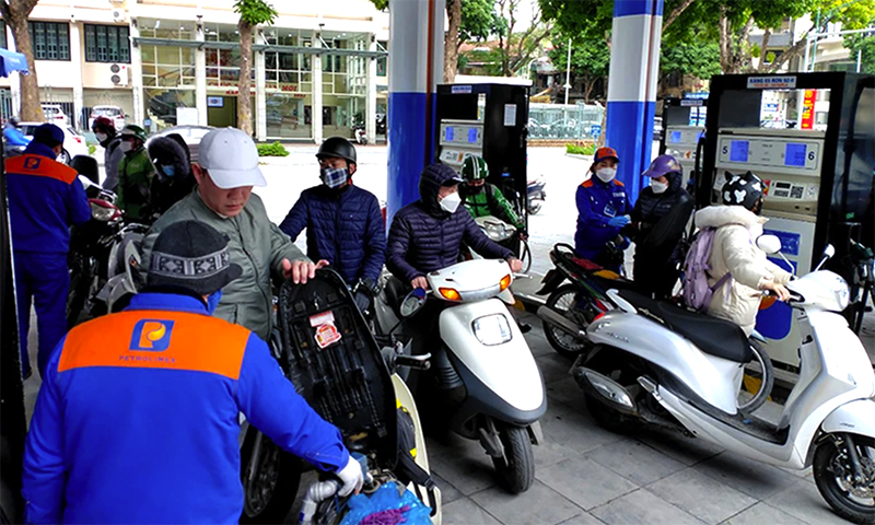 Người dân mua xăng tại cây xăng dầu trên phố Trần Hưng Đạo, quận Hoàn Kiếm, Hà Nội. (Ảnh Nguyễn Đăng)