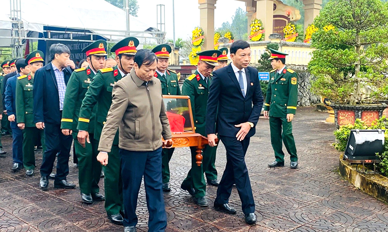 Các đại biểu thực hiện nghi lễ di chuyển hài cốt liệt sỹ về an táng tại tại Nghĩa trang liệt sỹ huyện Minh Hóa.