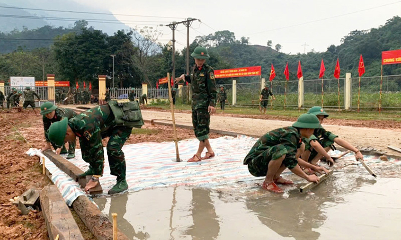 Cán bộ, chiến sĩ Trung đoàn 1 đổ bê tông đường vào và sân Nhà văn hóa bản Bãi Dinh. 