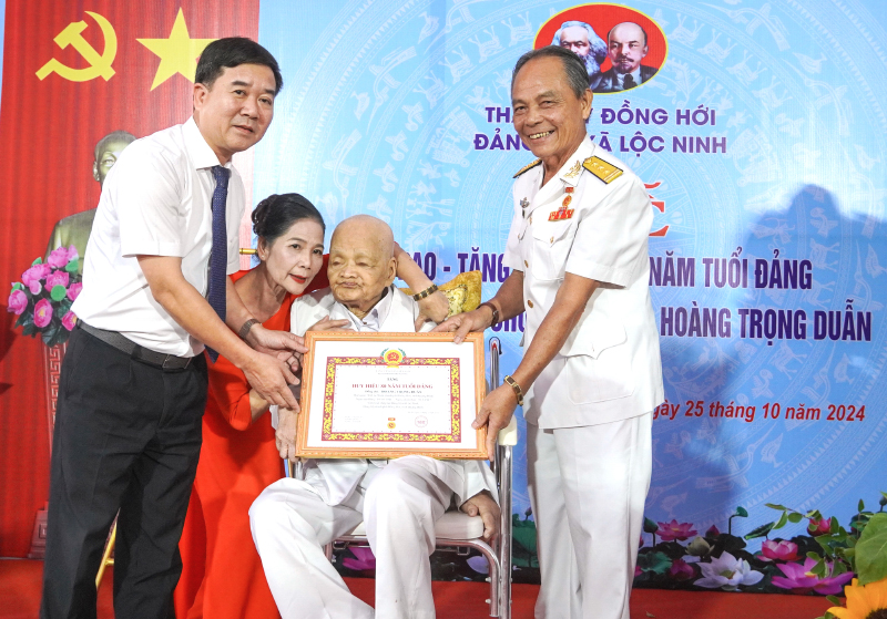 Đại diện lãnh đạo TP. Đồng Hới và người con trai cụ Duẫn trong ngày ông đón nhận Huy hiệu 80 năm tuổi Đảng.