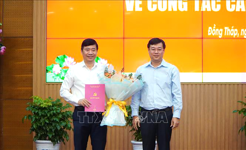 Ông Phạm Thiện Nghĩa, Phó Bí thư Tỉnh ủy, Chủ tịch UBND tỉnh Đồng Tháp (bên trái) nhận Quyết định về việc nghỉ hưu trước tuổi từ ngày 15/2/2025. Ảnh: Nhựt An/TTXVN