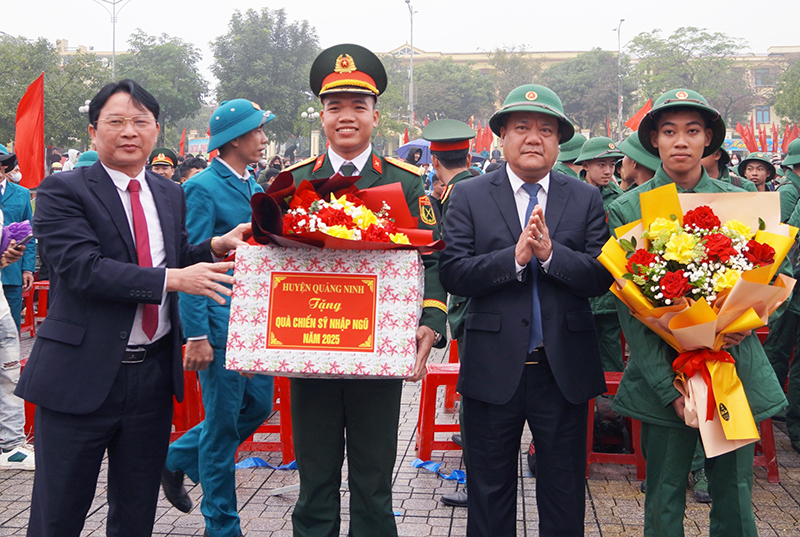 Đồng chí Chủ tịch UBND tỉnh Trần Phong và lãnh đạo huyện Quảng Ninh tặng hoa chúc mừng các tân binh.