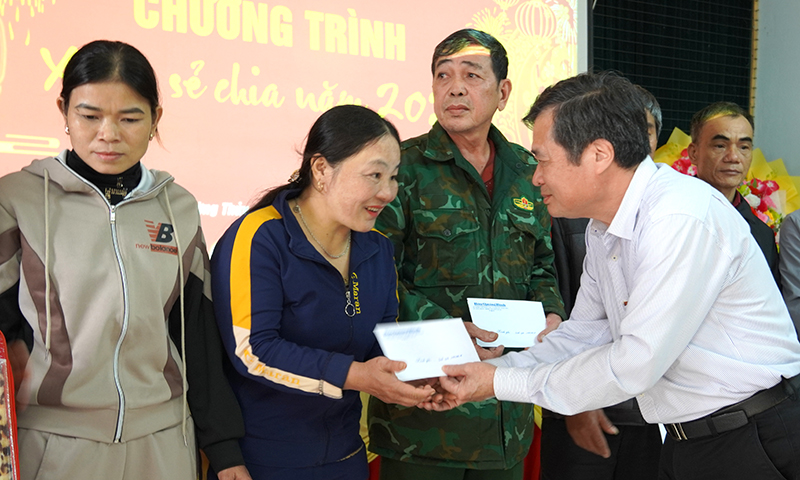 Đại diện lãnh đạo Báo Quảng Bình và xã Trường Thủy trao quà cho học sinh hoàn cảnh khó khăn.