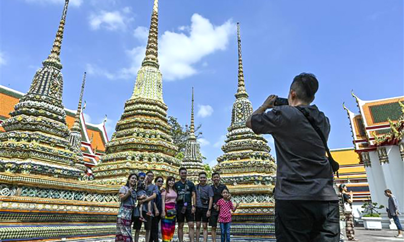 Khách du lịch chụp ảnh tại chùa Wat Pho ở thủ đô Bangkok. Ảnh: AFP/TTXVN