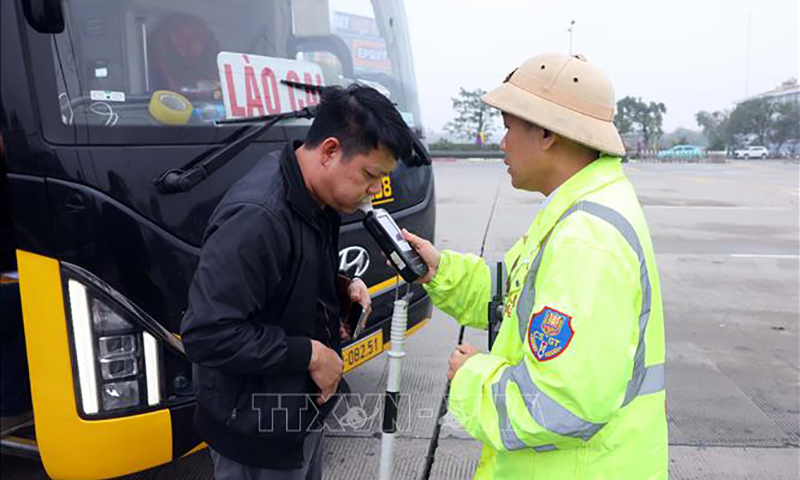Cán bộ, chiến sĩ CSGT đội 3 (Phòng Hướng dẫn tuần tra, kiểm soát giao thông đường bộ, đường sắt, Cục CSGT) kiểm tra nồng độ cồn đối với tài xế xe khách trên tuyến cao tốc Pháp Vân - Cầu Giẽ. Ảnh: Phạm Kiên/TTXVN