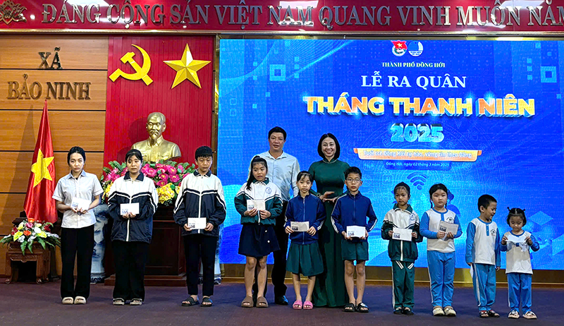 Đại diện lãnh đạo TP. Đồng Hới và đơn vị phối hợp trao quà cho các em học sinh có hoàn cảnh khó khăn.