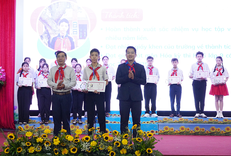 Đại diện lãnh đạo huyện Bố Trạch, Hội đồng Đội tỉnh trao tặng biểu trưng và giấy chứng nhận “Cháu ngoan Bác Hồ” cho các đội viên tiêu biểu.