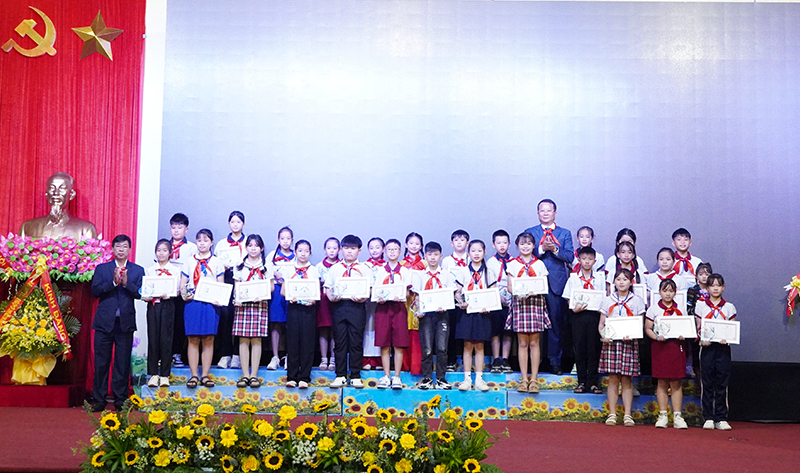 Đại diện lãnh đạo huyện Bố Trạch, Hội đồng Đội tỉnh trao tặng biểu trưng và giấy chứng nhận “Cháu ngoan Bác Hồ” cho các đội viên tiêu biểu.