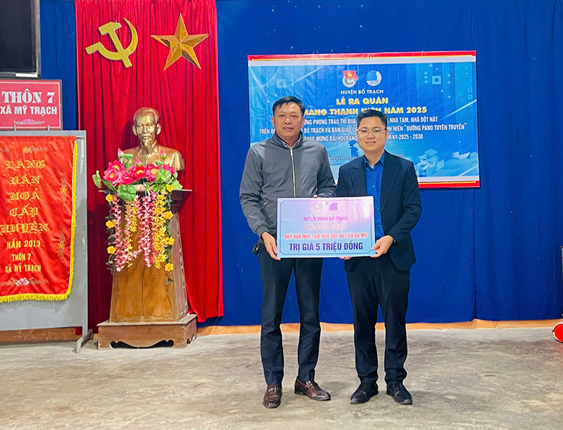 Đại diện lãnh đạo Huyện đoàn Bố Trạch trao biển hỗ trợ kinh phí vào quỹ xóa nhà tạm, nhà dột nát cho xã Hạ Mỹ.