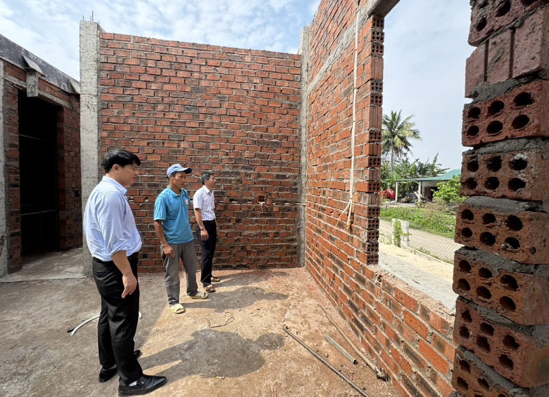 Cán bộ địa phương thăm hỏi, động viên gia đình được hỗ trợ xóa nhà tạm, nhà dột nát.