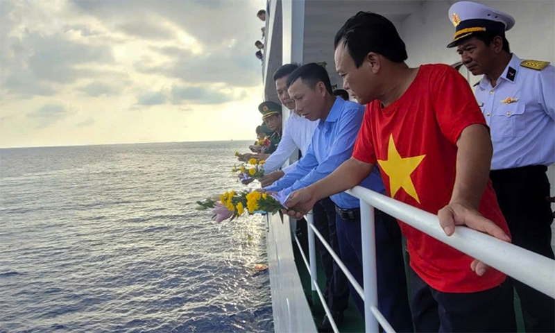 Anh Nguyễn Đình Thế (mặc áo xanh) cùng đoàn công tác thả hoa tri ân liệt sĩ Gạc Ma.