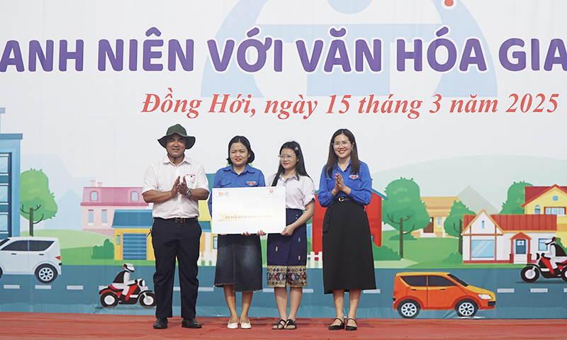 Trao biển tượng trưng tặng mũ bảo hiểm cho các hoàn cảnh khó khăn.