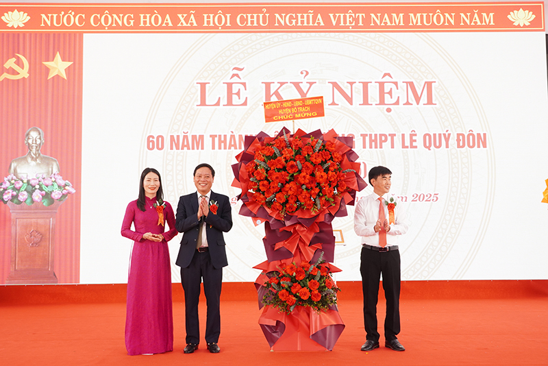 Đại diện lãnh đạo huyện Bố Trạch tặng hoa chúc mừng Trường THPT Lê Quý Đôn.